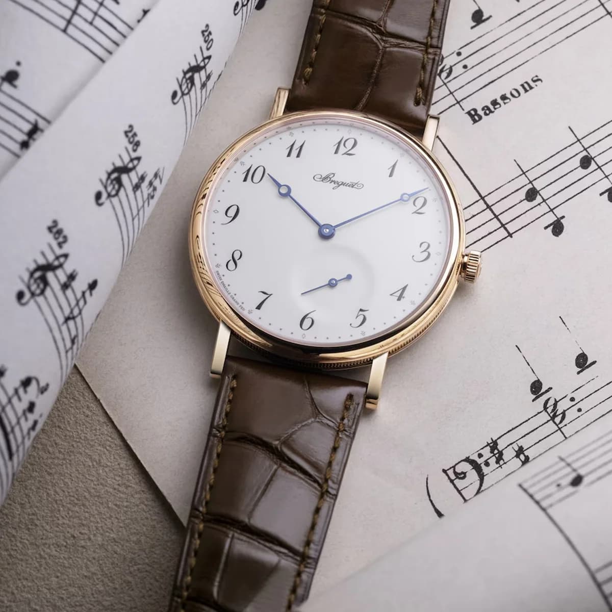 Crown detail showing the non-screwed rose gold crown against the coin-edge case band