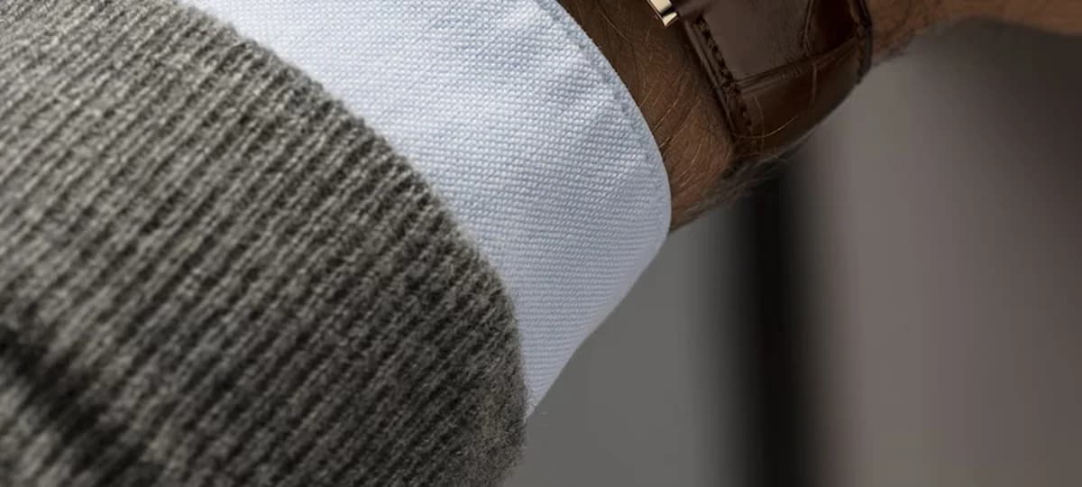 On wrist showing how the 40mm case and 6.5mm thickness sit under a shirt cuff