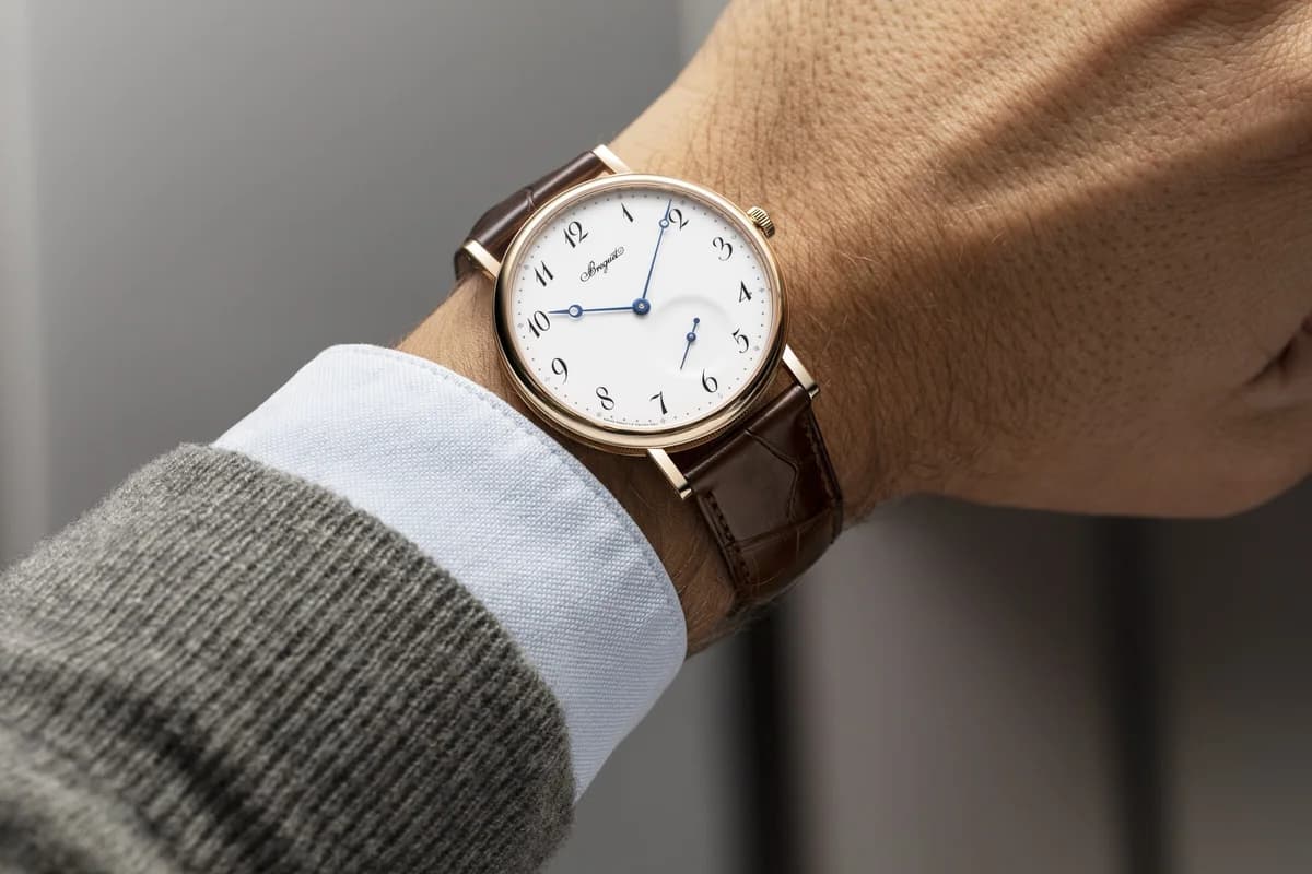 Angled view highlighting the coin-edge bezel pattern and straight lugs against sheet music