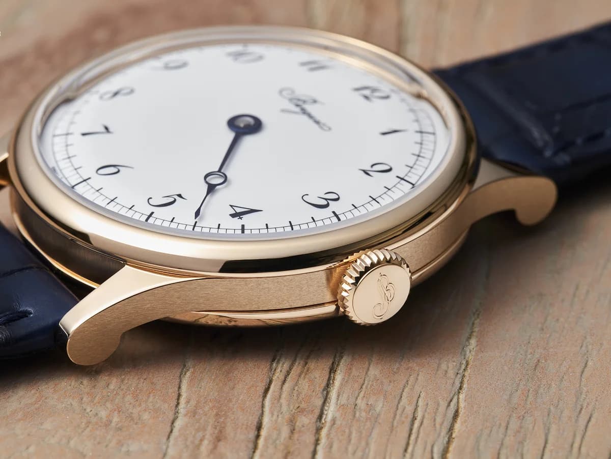 Macro of the flame-blued Breguet pomme hand showing mirror-polished chamfered edges and the enamel numerals