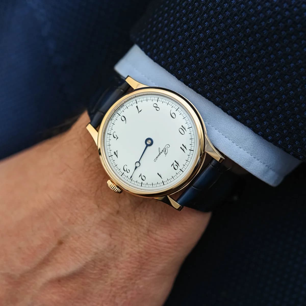 The 18K Breguet gold pin buckle on the navy alligator strap, matching the case color perfectly