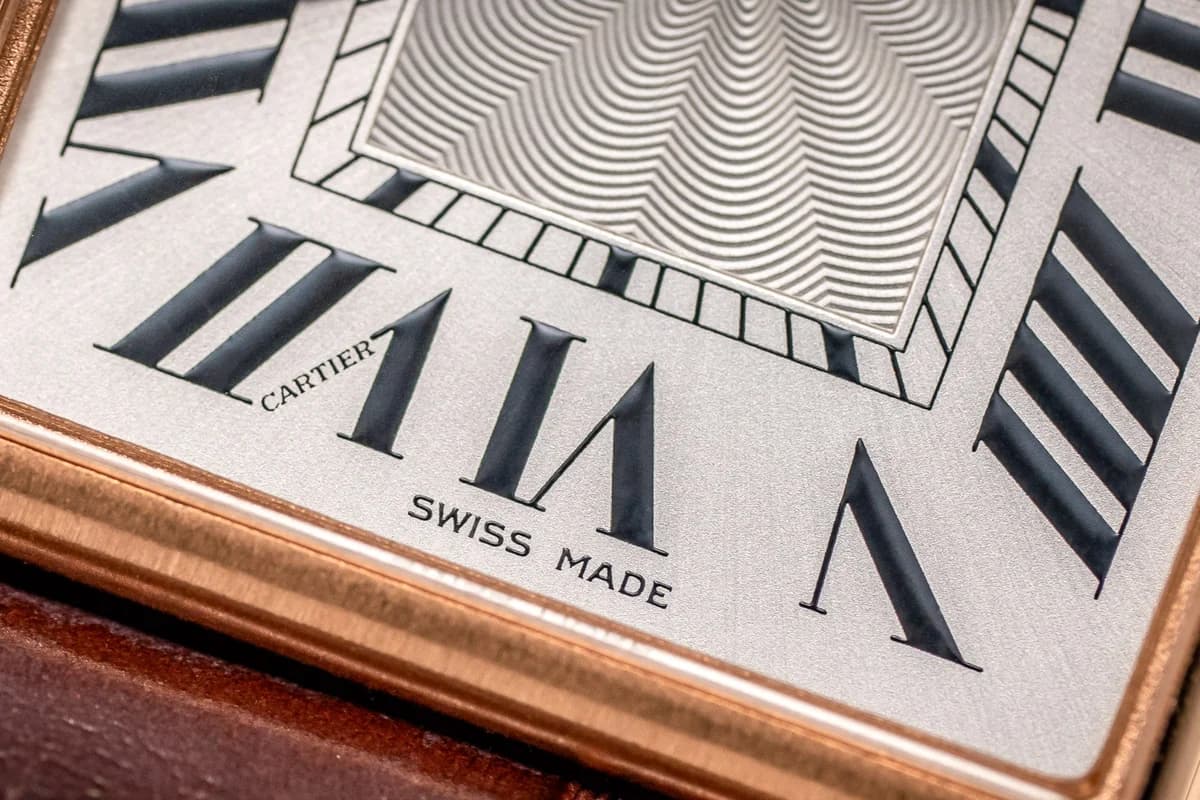 Dial macro showing the elongated Roman numerals and guilloched center. The heat-blued steel hands shift from deep navy to vivid blue depending on the angle of light.