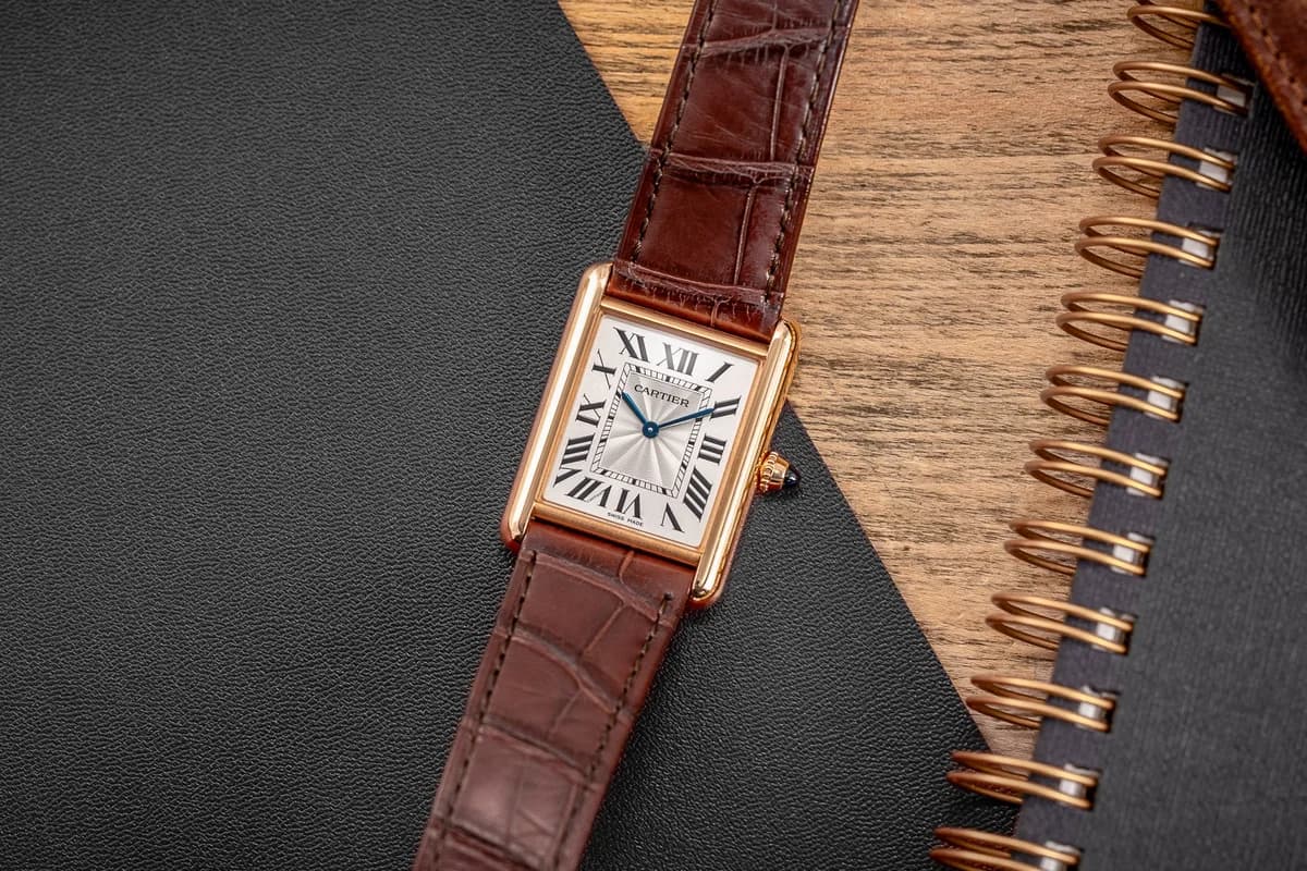 The full watch on brown alligator strap. The brancards, those vertical bars framing the dial, flow seamlessly into the strap attachments. That integration of case and strap was the Tank's original innovation.