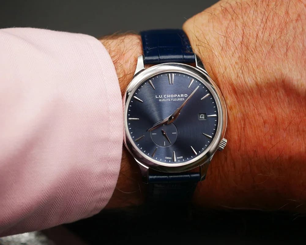 The Twist QF on a textured leather surface, showing the blue-grey alligator strap and white gold case together