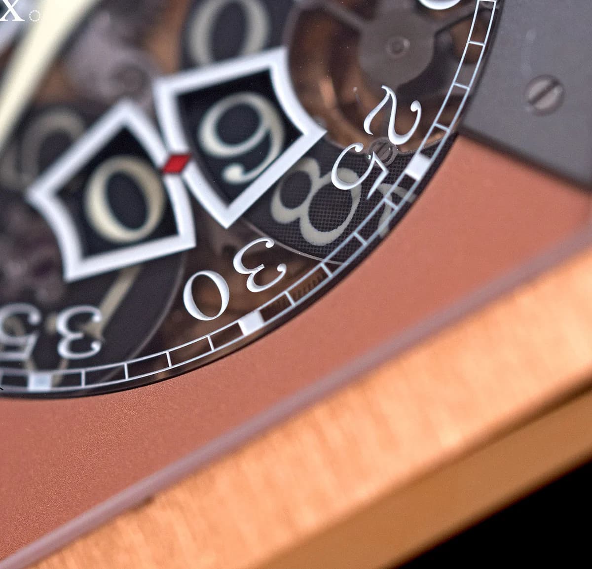Dial detail of the rose gold version showing the jumping seconds windows and visible gear train beneath the sapphire
