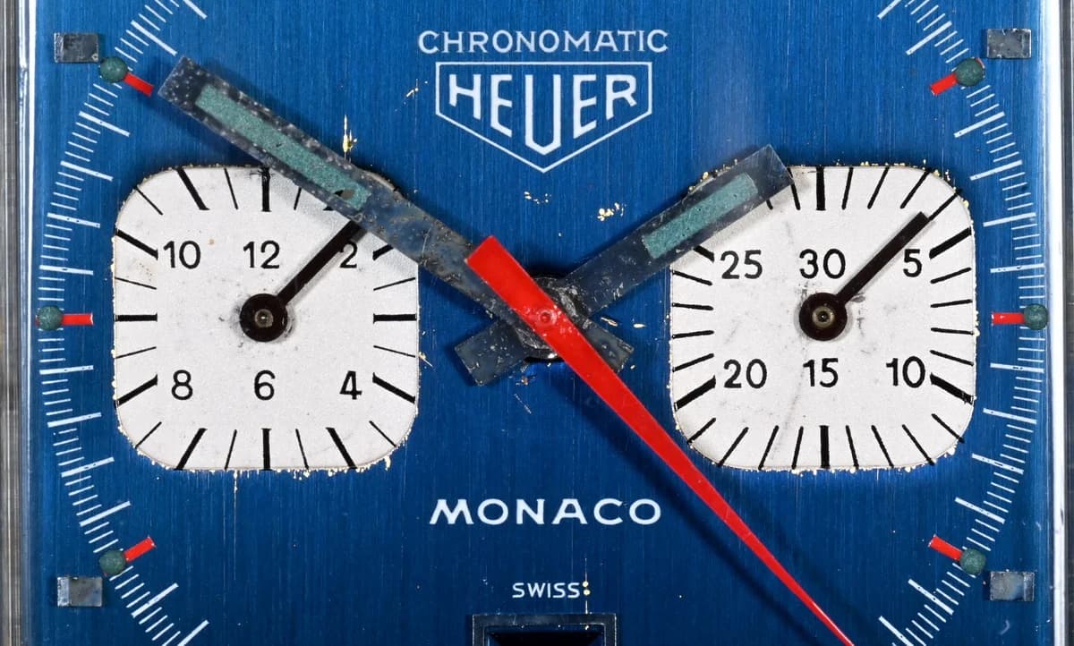 The Monaco dial, bracelet clasp, and case separated during service. The Heuer shield clasp and the dial's edge wear are visible.