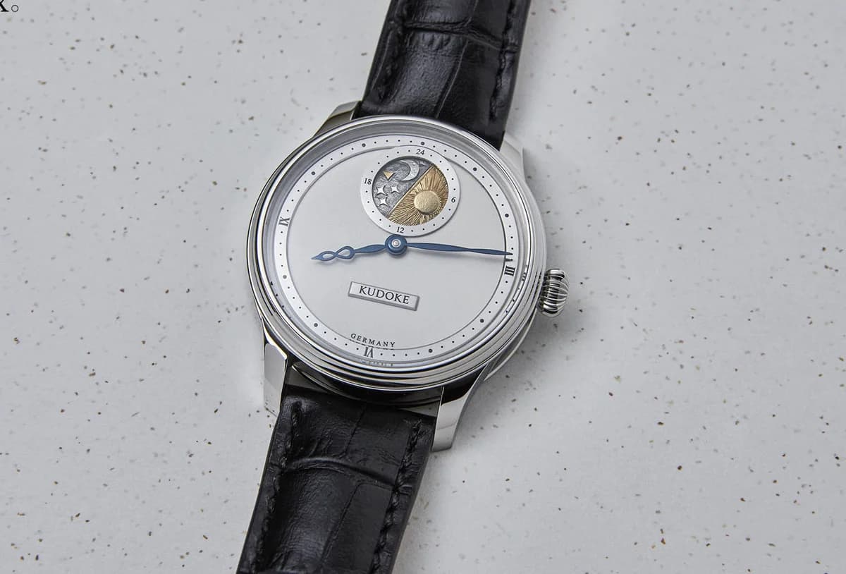 The Kudoke 2 with its frosted silver dial, hand-engraved day-night disc, and blued infinity-symbol hands