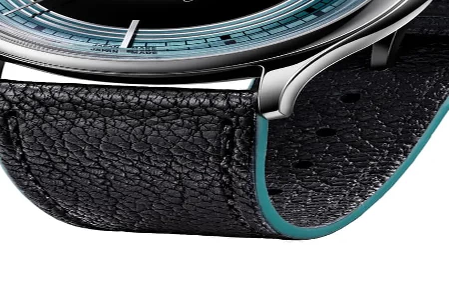 Black calf leather strap with green-embellished sides, a detail that ties back to the dial