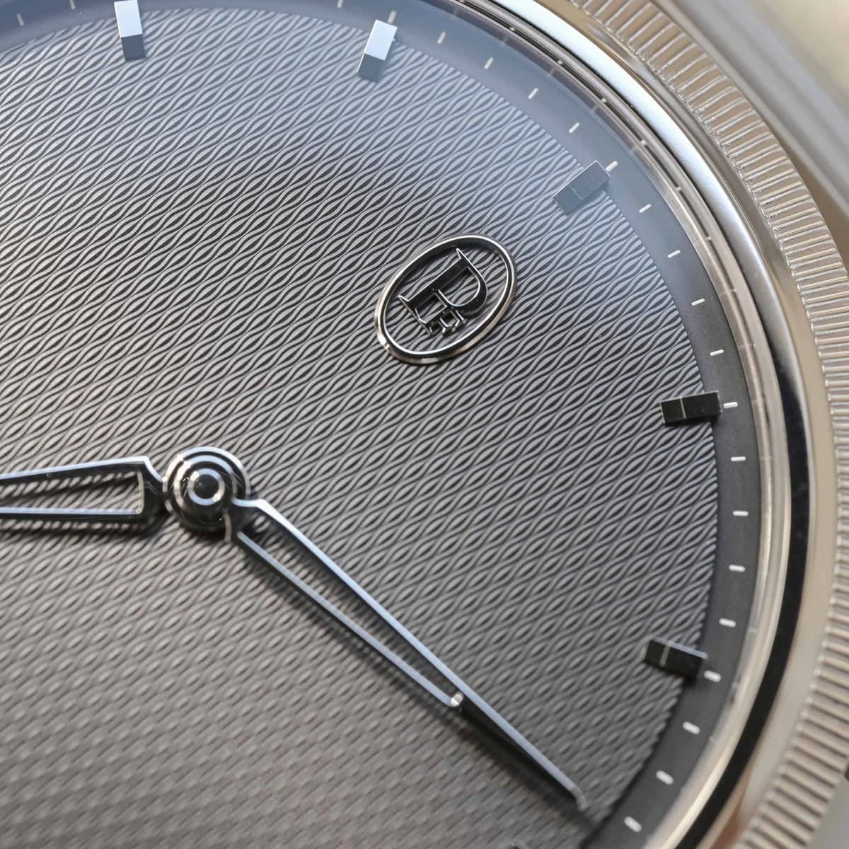 Three-quarter view showing the integrated bracelet flowing from the tear-drop lugs and the hand-knurled platinum bezel