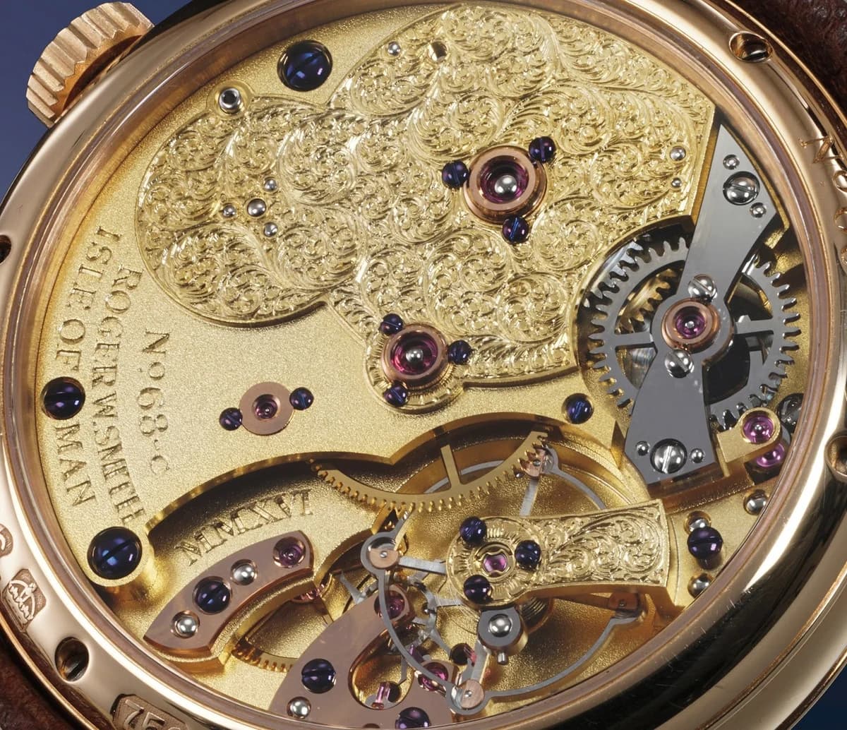 Caseback of the platinum Series 2 Open Dial showing the hand-engraved movement with Roger W. Smith and Isle of Man inscriptions. The co-axial escapement and balance wheel are visible at the lower right.
