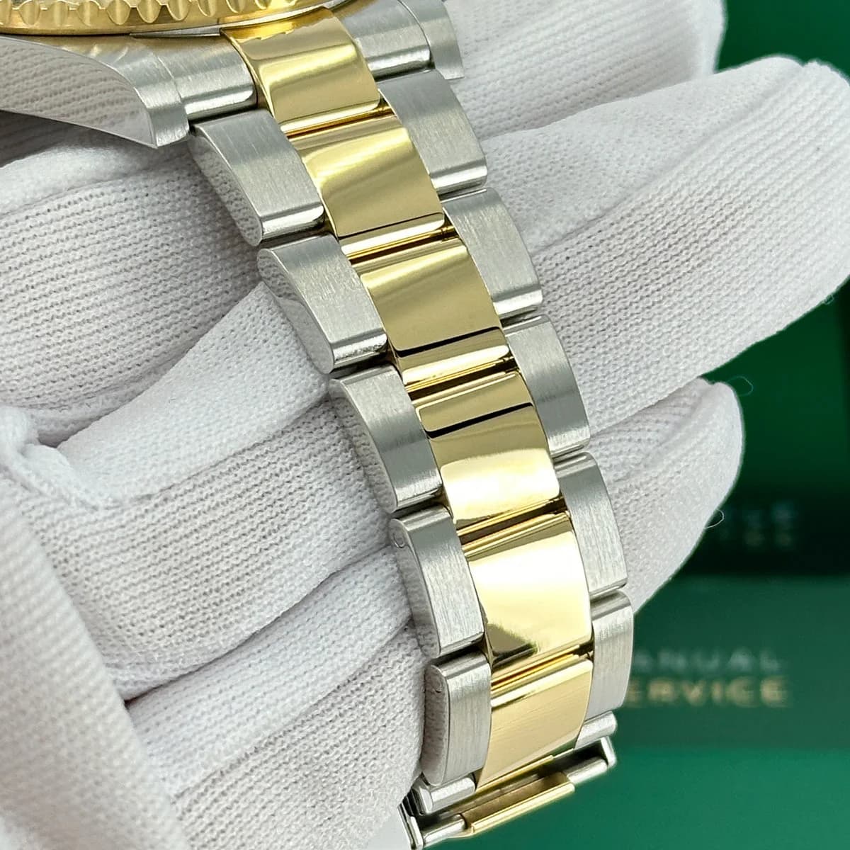 Polished gold center links and brushed steel outer links create visual rhythm
