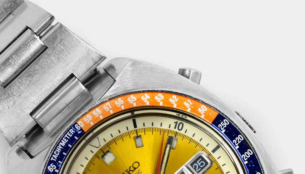 Dial macro showing the yellow sunburst finish, applied indices, and 30-minute chronograph register at 6 o'clock.