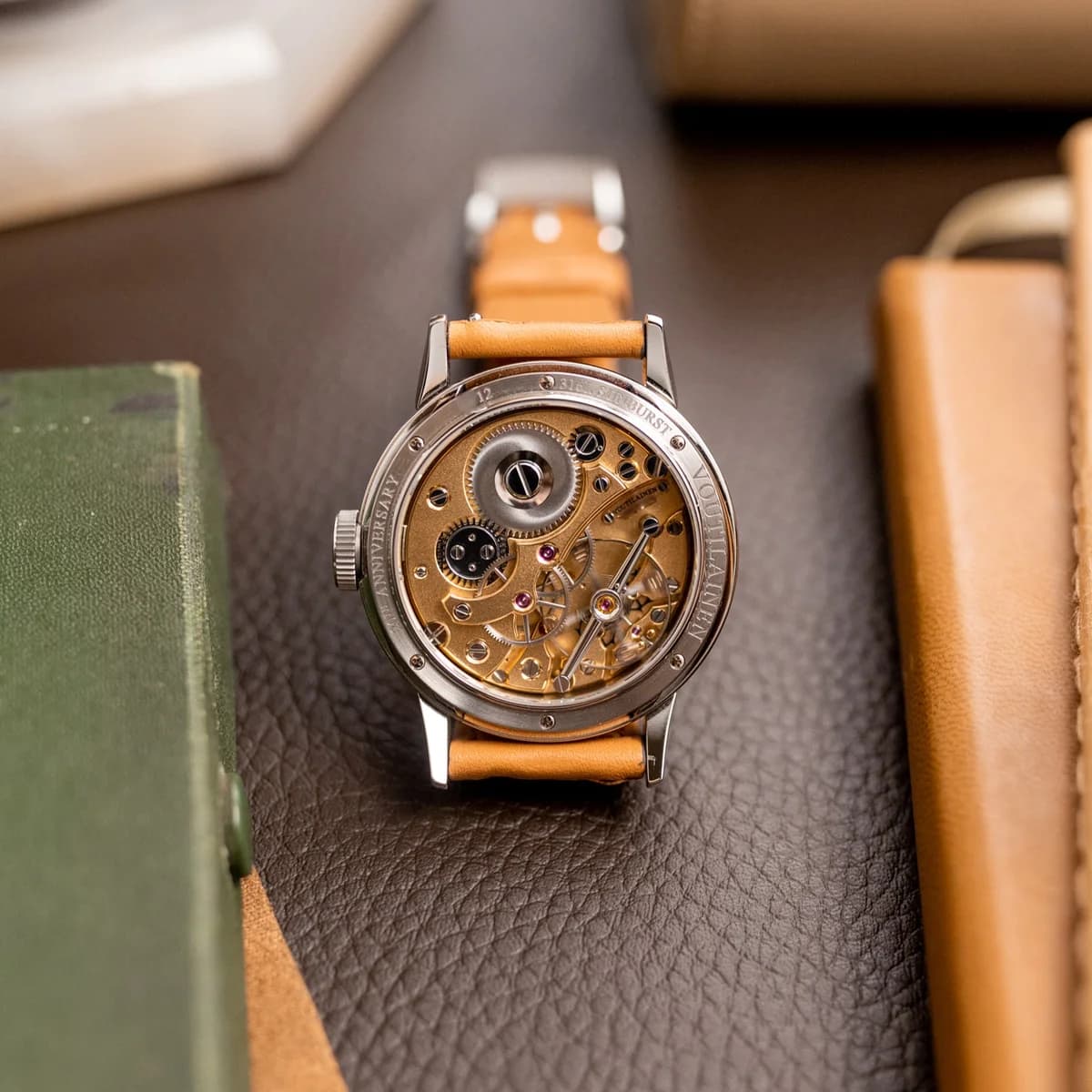The 28SC-SB in hand, showing the two-tone guilloche dial with gold sunburst center