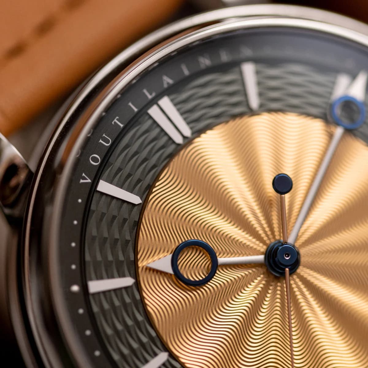 Concave bezel detail from above showing the inward curve toward the sapphire crystal, lug attachment, and VOUTILAINEN branding