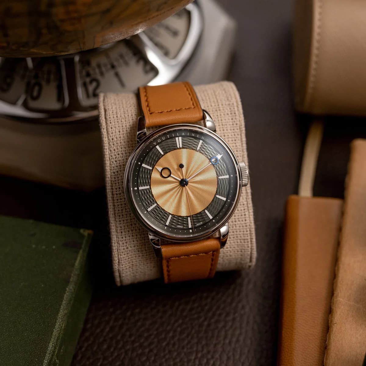 Crown detail at 3 o'clock showing the in-house knurled crown, case edge, and gold sunburst guilloche center